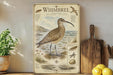 A vintage-style illustration of a Whimbrel, a wading bird, is displayed on a wooden shelf next to a potted plant and a wooden cutting board.