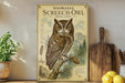 a poster of a Whiskered Screech- Owl, which is a large bird of prey, displayed on a shelf next to a wooden cutting board and some potted plants.
