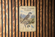 a poster of a white-crowned sparrow, which is mounted on a wooden wall.