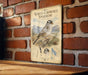 a vintage-style metal sign with an illustration of a white-crowned sparrow, mounted on a brick wall.