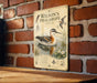A vintage-style illustration of a bird, likely a phalarope, swimming in a body of water, with various botanical illustrations and text surrounding the image.