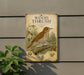 a vintage-style metal sign with a detailed illustration of a bird perched on a branch, surrounded by flowers and foliage.