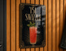 A sign for "151 SWIZZLE" cocktail, featuring an illustration of a red drink with a garnish and a straw.