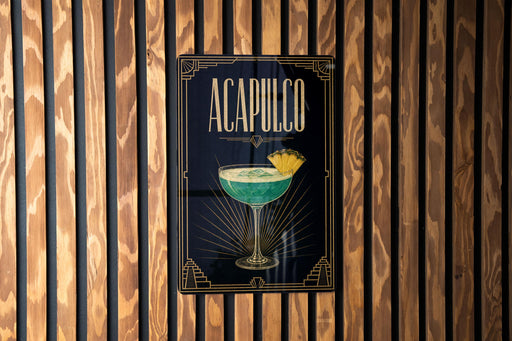 a poster or sign with the word "ACAPULCO" prominently displayed, along with an illustration of a cocktail glass containing a green drink and a slice of lemon.