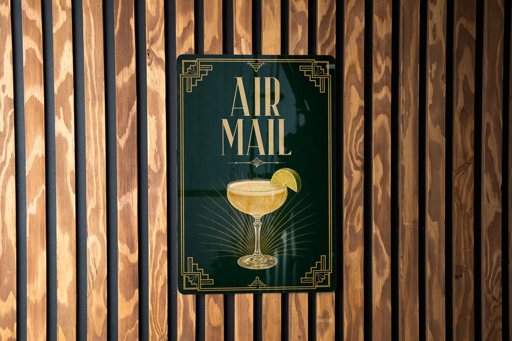 a sign that reads "AIR MAIL" with a picture of a cocktail on it, mounted on a wooden wall.