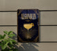 A sign for Algonquin cocktail, featuring a glass of the drink with a lemon twist, is displayed on a wall.