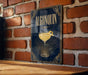 A sign with the word "ALGONQUIN" and an illustration of a cocktail glass is displayed on a brick wall.