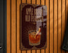 A sign with the text "APPLE BRANDY OLD FASHIONED" and an illustration of a glass of amber-colored liquid with a slice of apple on top.