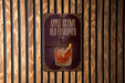 A sign for Apple Brandy Old Fasioned whiskey, featuring an illustration of a glass of the drink with a slice of apple on the rim.