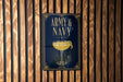 A poster with the text "ARMY & NAVY" and an illustration of a cocktail glass is displayed on a wooden wall.