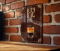 A sign with the text "B-52" and an illustration of a layered drink, likely a cocktail, is displayed on a brick wall.