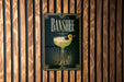 A poster with the word "BANSHEE" and an illustration of a cocktail is displayed on a wooden wall.