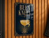 A sign that reads "BEES KNEE'S" with an illustration of a cocktail glass and a lemon peel.