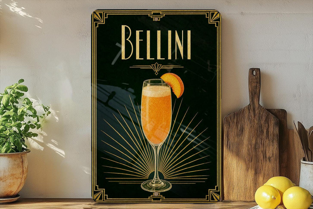 A framed poster of a champagne glass with a slice of orange on a black background, surrounded by decorative elements such as a wooden cutting board and a potted plant.