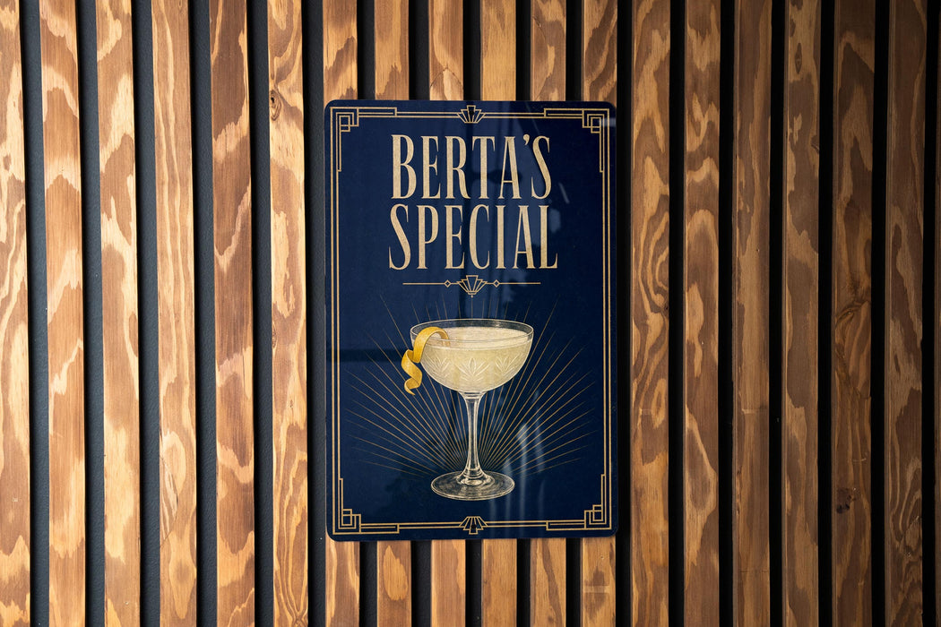A sign for "Berta's Special" cocktail, featuring an illustration of a cocktail glass with a lemon twist.