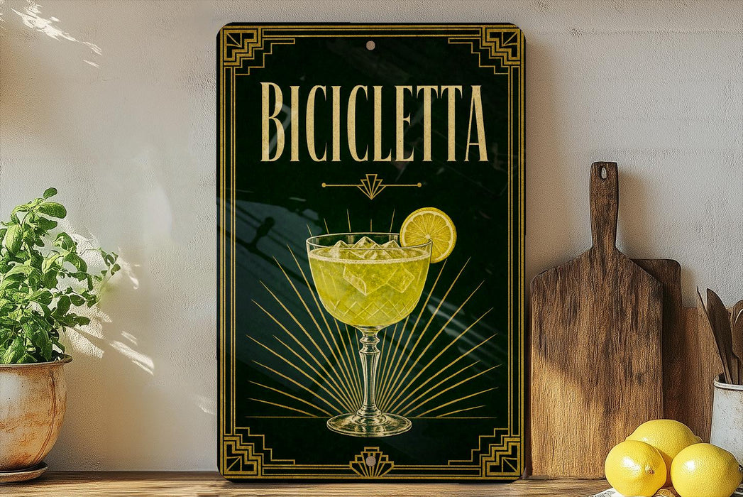 a decorative sign with the word "BICICLEETTA" on it, along with an illustration of a glass containing a yellow drink and a lemon slice. The sign is displayed on a shelf, surrounded by various kitchen items such as a wooden cutting board, a lemon, and a potted plant.