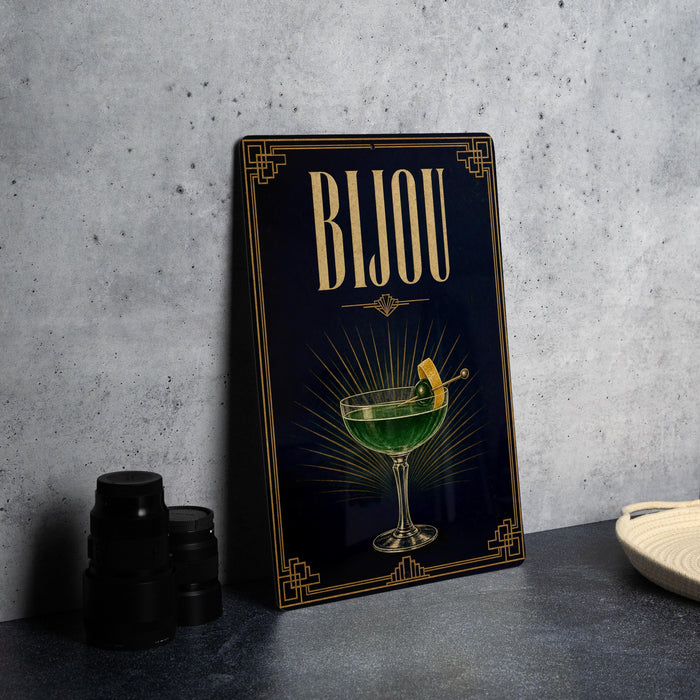 A framed poster with the word "BJOU" prominently displayed, featuring an illustration of a cocktail glass with a lemon slice.