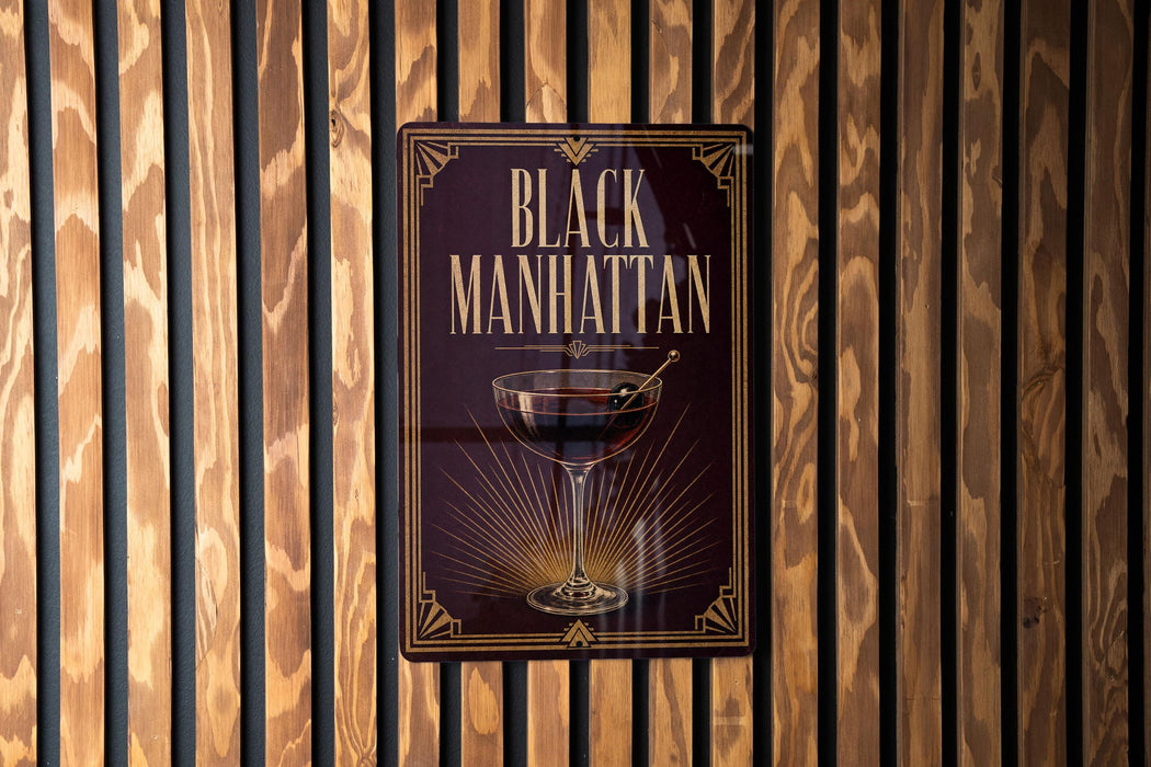 A sign for "Black Manhattan" cocktail is displayed on a wooden wall.