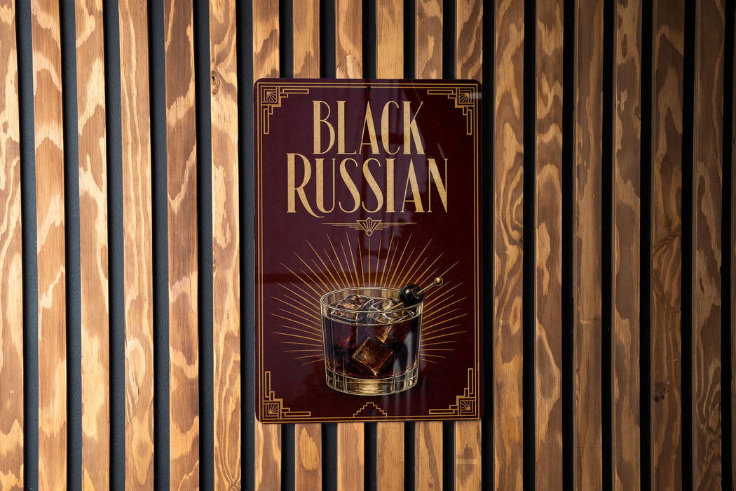 a sign with the text "Black Russian" and an illustration of a glass containing a dark liquid, likely a cocktail or a similar type of drink.