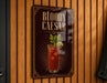 A sign for a Bloody Caesar cocktail is displayed on a wooden wall.