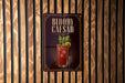 A sign for a Bloody Caesar cocktail is displayed against a wooden wall.