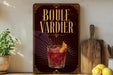 A framed advertisement for a drink called "Boule Vardier" featuring a glass of red cocktail with a lemon slice.