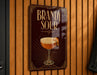 A sign for "Brandy Sour" is displayed on a wooden wall.