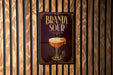 A sign for "Bandy Sour" cocktail is displayed on a wooden wall.