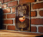 A framed poster of a cocktail called "Brown Derby" is displayed on a brick wall.