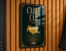 A sign that reads "CABLE CAR" with an illustration of a cocktail glass and a lemon peel on a wooden wall.