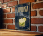 A poster or sign for a Caipiroski cocktail, featuring a glass of the drink with a lime slice, against a brick wall background.