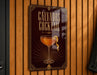 A sign for a cocktail called "Calvados Cocktail" is displayed on a wooden wall.