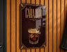 A sign for CaraJillo, a cocktail, is displayed on a wooden wall.