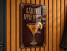 A sign for a caramel apple martini is displayed on a wooden wall.