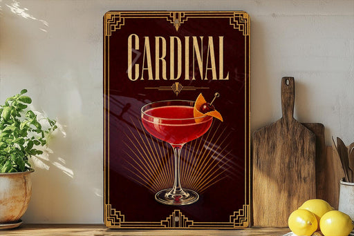 A decorative sign for a "Cardinal" cocktail, featuring a glass of red cocktail with a cherry on top, is displayed on a wooden shelf next to a cutting board and some lemons.