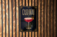 A poster with the word "CASTAWAY" and an illustration of a cocktail on a wooden wall.