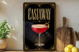 a framed poster of a cocktail glass with a garnish, placed on a shelf next to a wooden cutting board and some lemons.