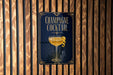 A poster advertising a champagne cocktail is displayed on a wooden wall.