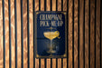 A sign with the text "CHAMPAGNE PICK-ME-UP" and an illustration of a champagne glass with a lemon twist.