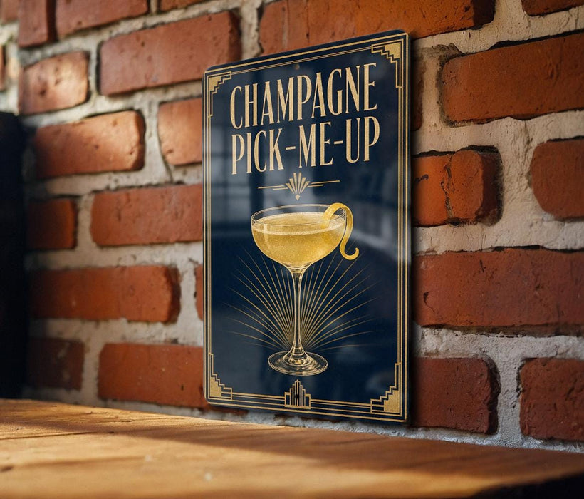 A sign with the text "CHAMPAGNE PICK-ME-UP" and an illustration of a champagne glass with a lemon twist.