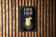 A poster for a drink called "Coco Loco" is displayed on a wooden wall.