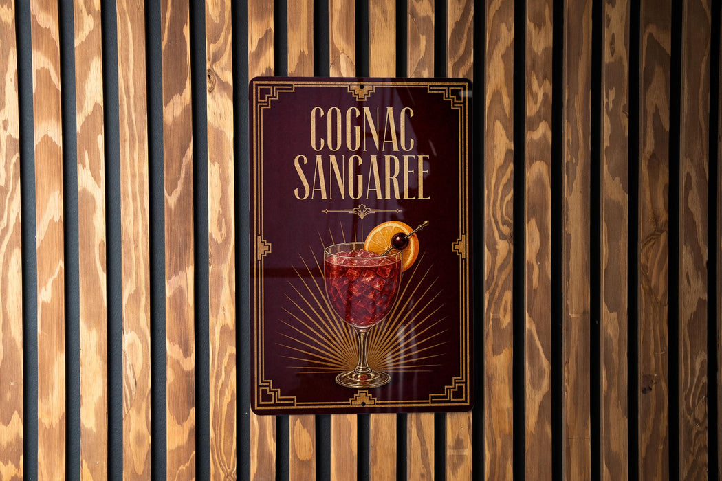 A sign for a cognac-sangaree cocktail is displayed on a wooden wall.