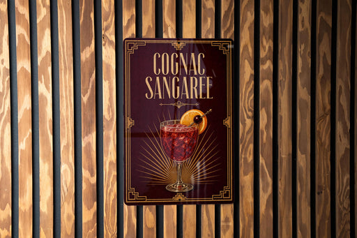 A sign for a cognac-sangaree cocktail is displayed on a wooden wall.