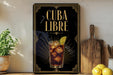 a poster with the text "CUBA LIBRE" and an illustration of a drink with ice cubes and a lime slice.