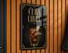 A sign with the text "CUBA LIBRE" and an illustration of a drink, likely a cocktail, with ice cubes and a lime wedge.