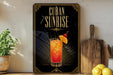 a decorative sign with the text "CUBA SUNRISE" and an illustration of a cocktail with a slice of orange on a wooden board.