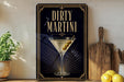 a framed poster of a martini glass with olives, placed on a shelf next to a wooden cutting board and a potted plant.