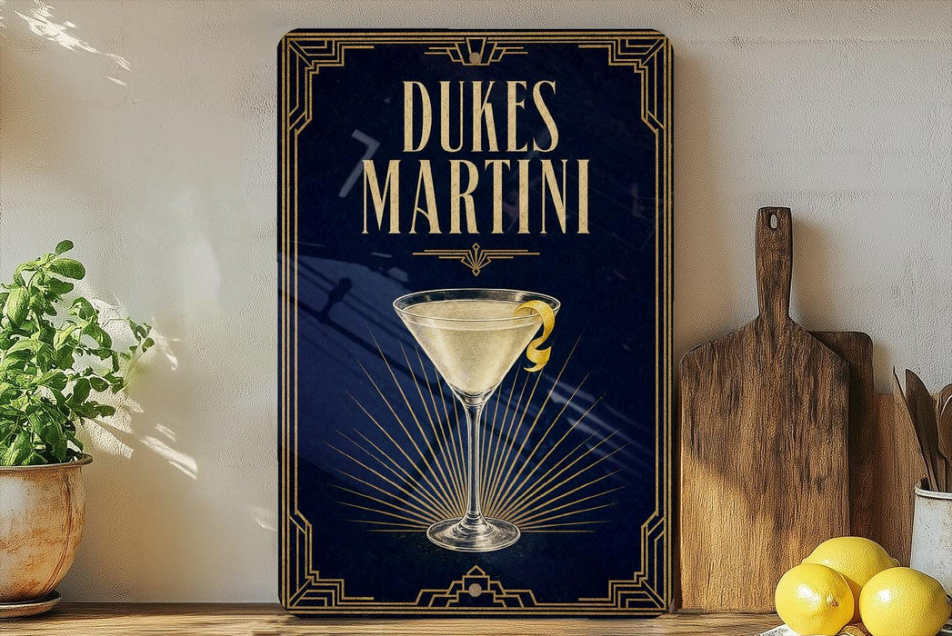 A framed poster of a Dukes Martini cocktail is displayed on a wall, with a wooden cutting board and a potted plant to the side.