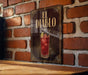 a sign for "El Diablo", which is a cocktail, hanging on a brick wall.