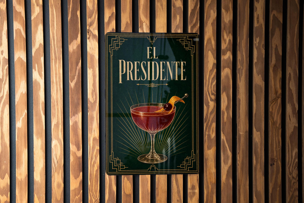 a sign with the title "EL PRESIDENTE" and an illustration of a cocktail glass with a lemon twist.
